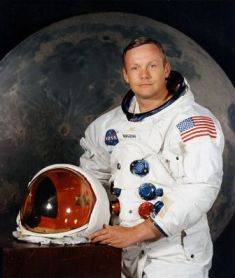 Neil Armstrong in spacesuit holding helmet