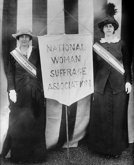 Women standing with suffrage sign
