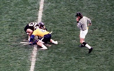 Referee overseeing a faceoff between players