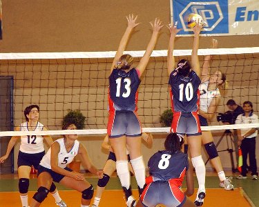 Volleyball players jumping to block a shot